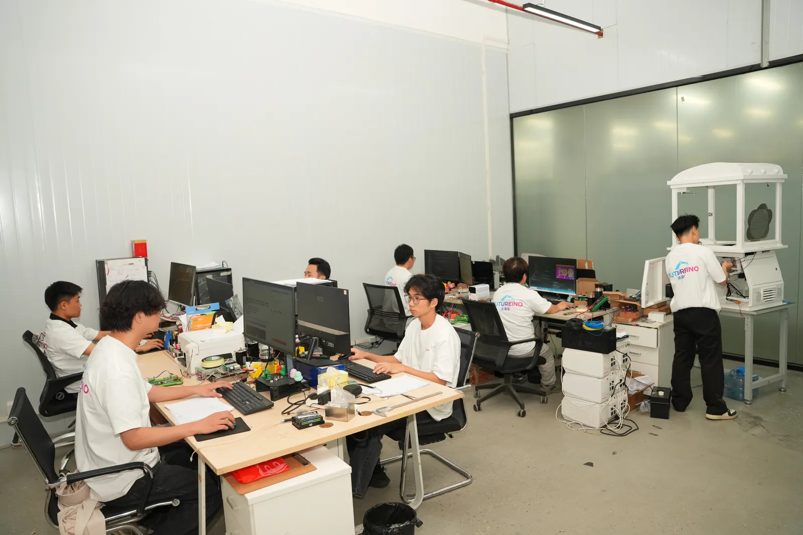 Engineers working on robotic vending machine components in Futureino's R&D lab in Guangzhou