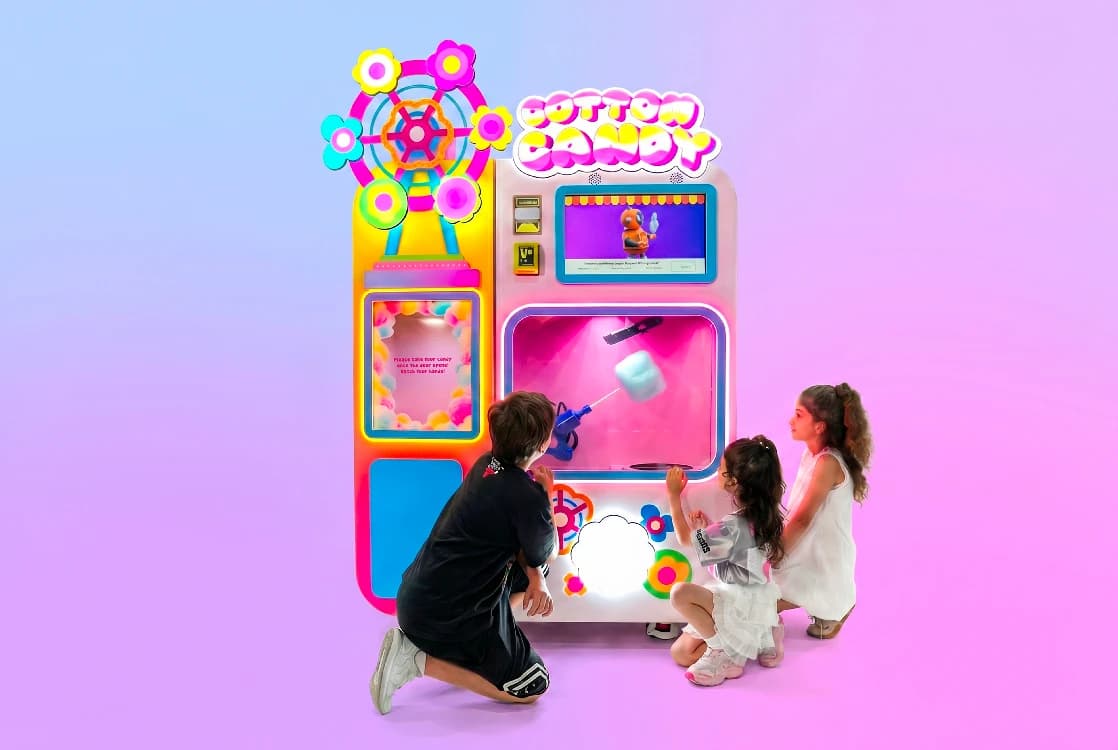Kids watching the Futureino cotton candy vending machine spin a fresh serving