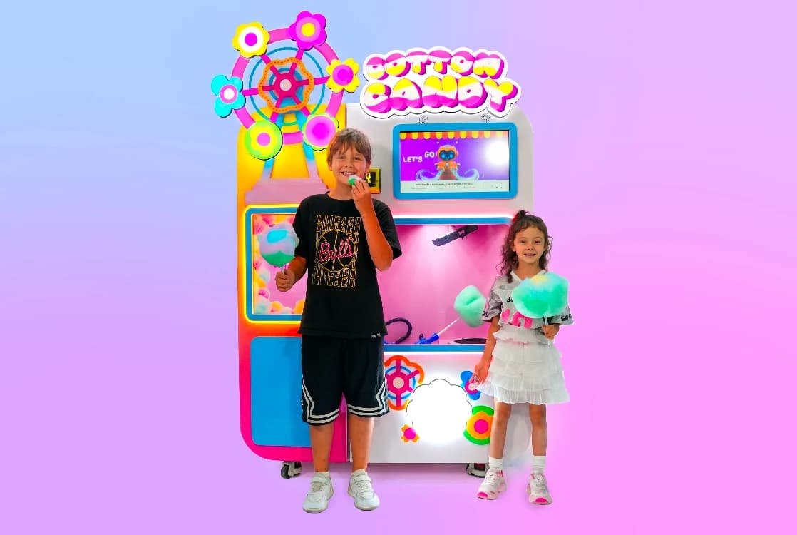 Boy and girl enjoying cotton candy next to the Futureino machine