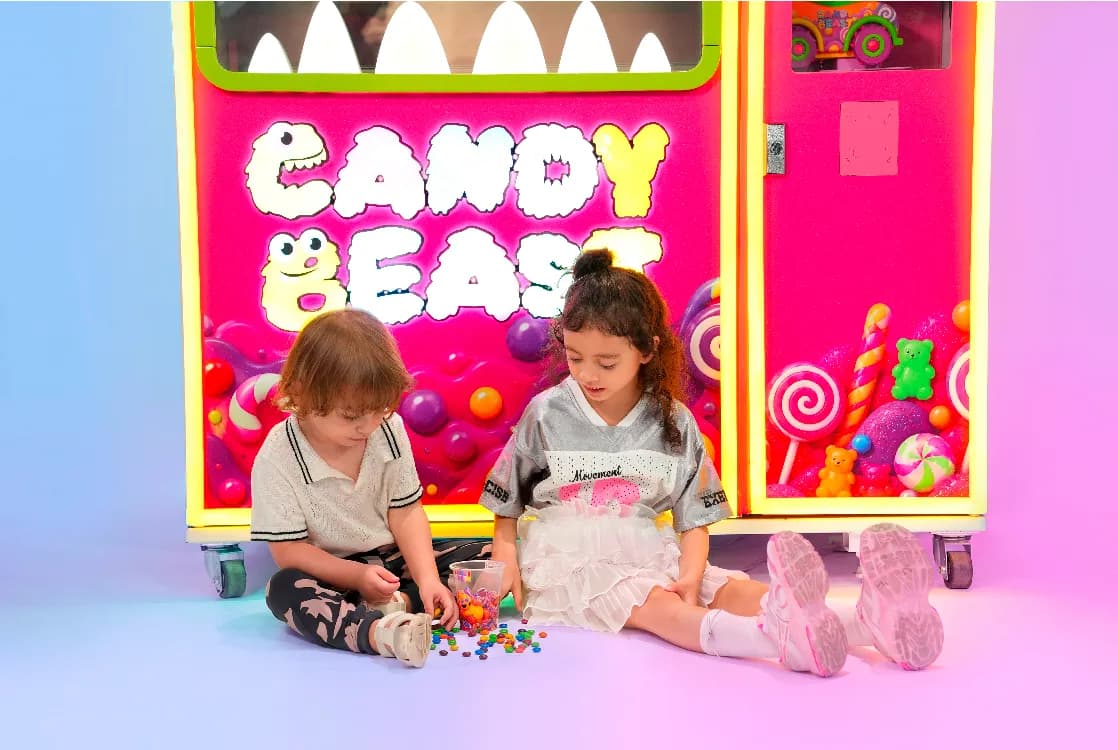 Kids playing with candies at the base of the Candy Beast machine