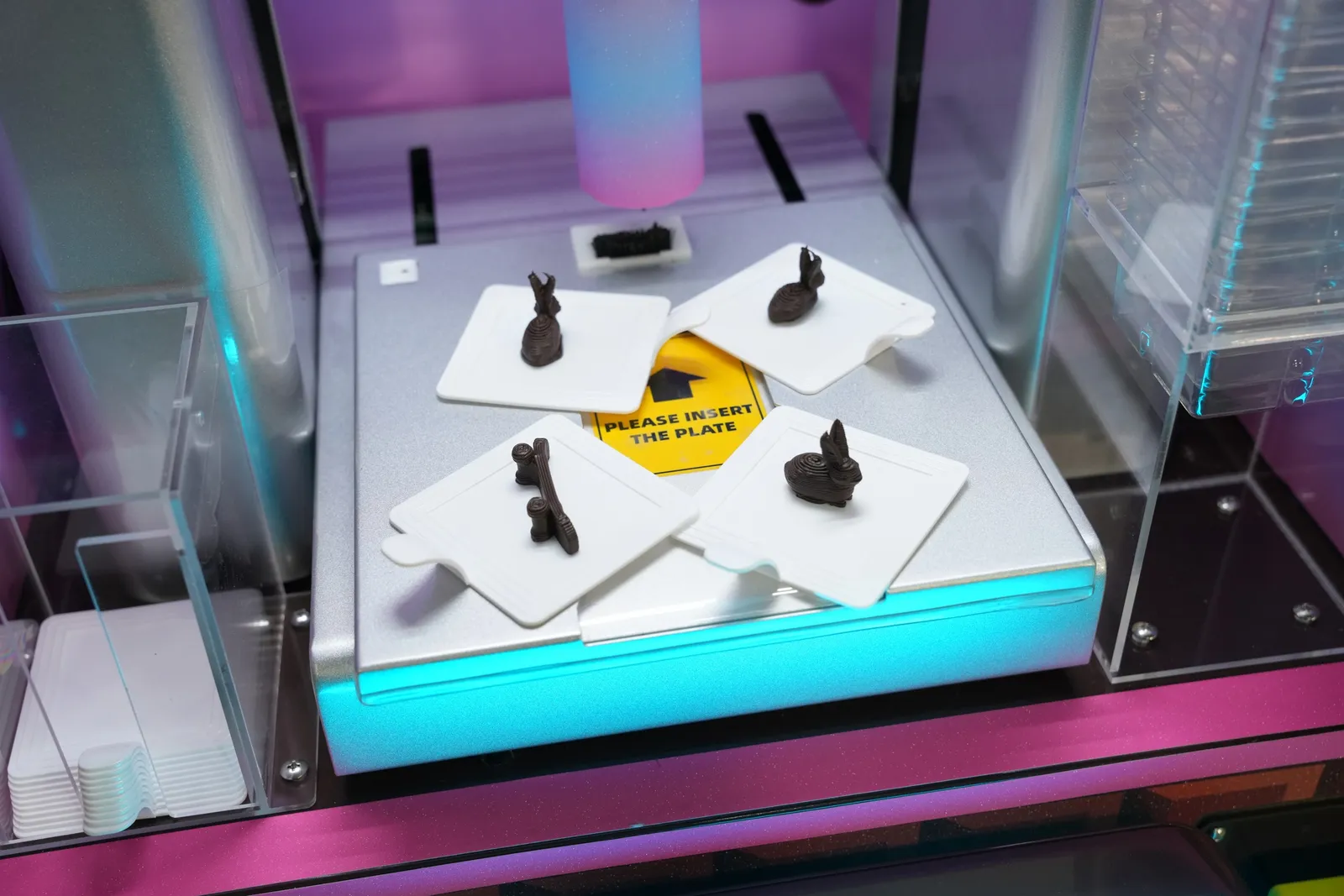 3D-printed chocolate bunnies on plates inside the ChocoArt chamber