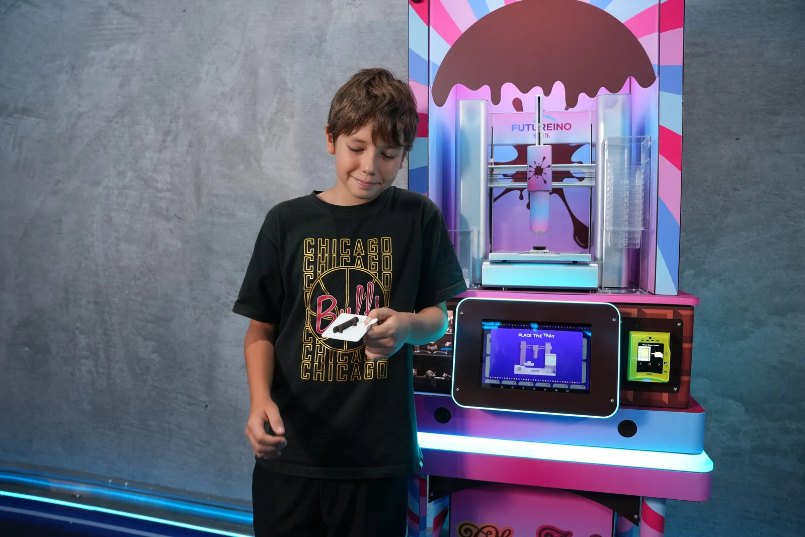 Boy holding his freshly printed chocolate at the ChocoArt machine