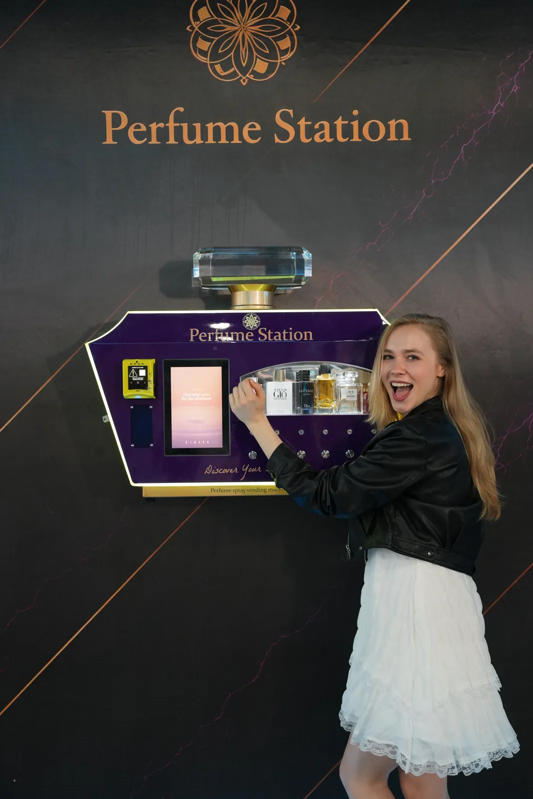 Smiling customer pressing a scent button on the Perfume Station